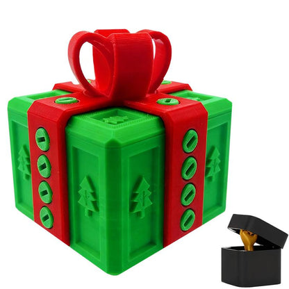 Green 3D-printed Christmas gift box with red ribbon and tree pattern, open black ring box with gold ring inside