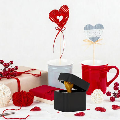 Valentine's Day gifts with red and white mugs, heart decorations, wrapped presents, and a black ring box